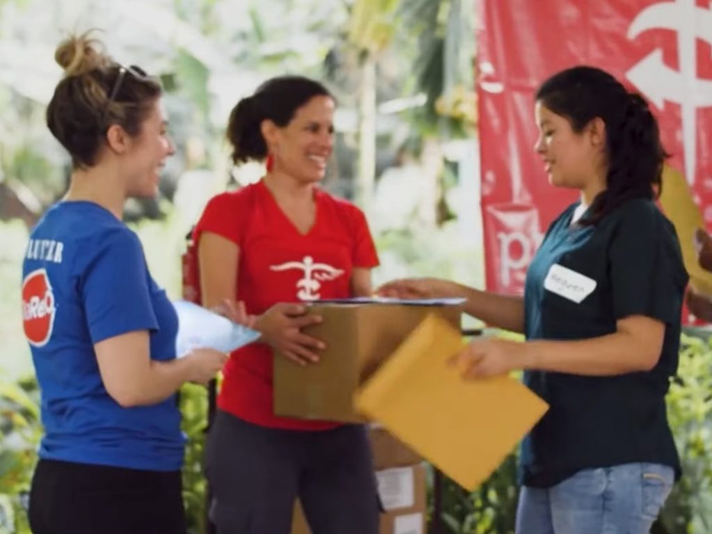 A group of Project CURE team members distributing medical supplies.