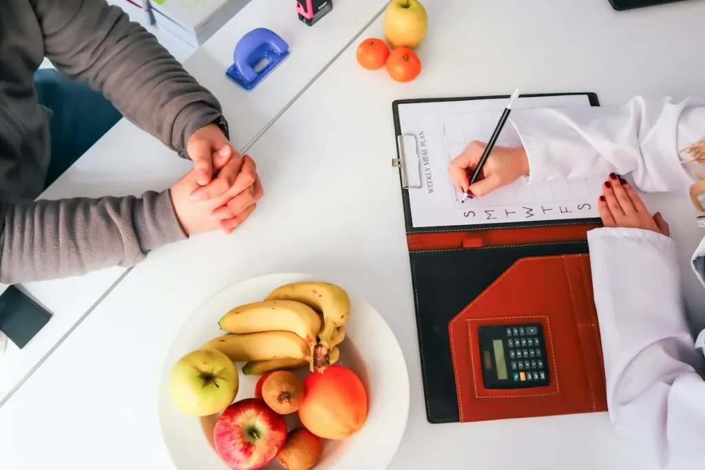A nutrition consultation with written notes and fruit on the table