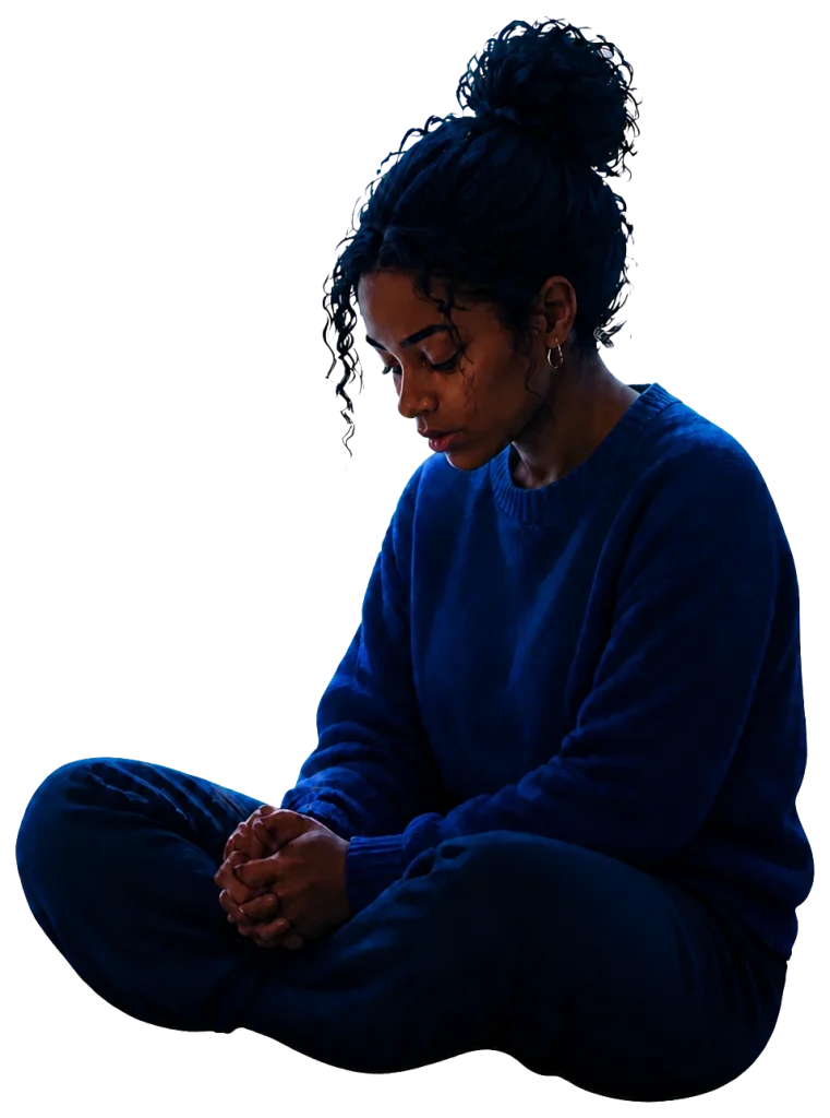 A woman sitting quietly with her hands clasped in reflection