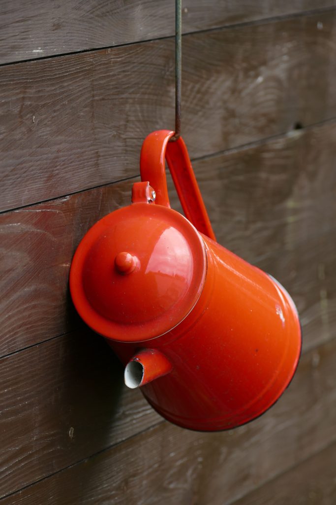Red air pump hanging on a wooden wall