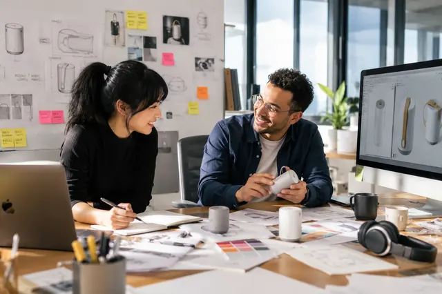 Product designers reviewing sketches, prototypes and product directions in a studio