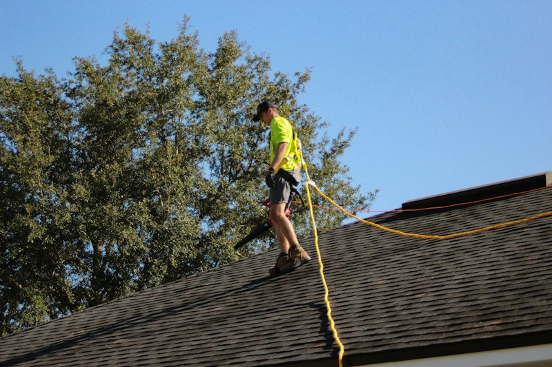 Roofer installing new asphalt shingles